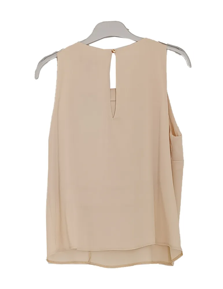 Beige satin sleeveless top with ruffle detail and floral brooch