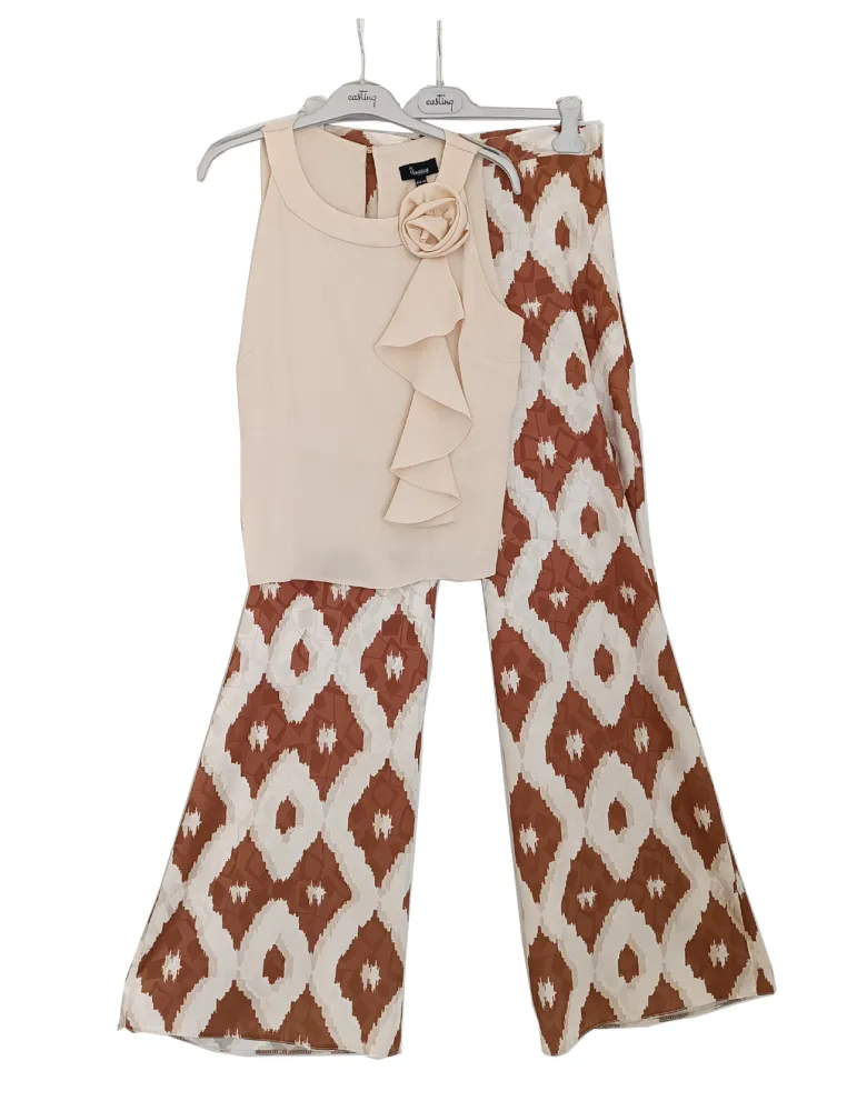 Beige satin sleeveless top with ruffle detail and floral brooch